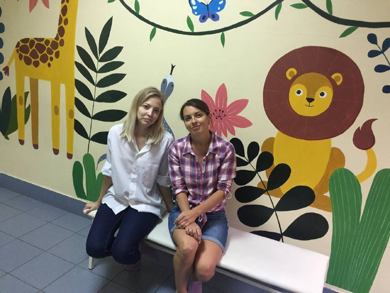 Кристина с командой у расписанной стены детской поликлиники